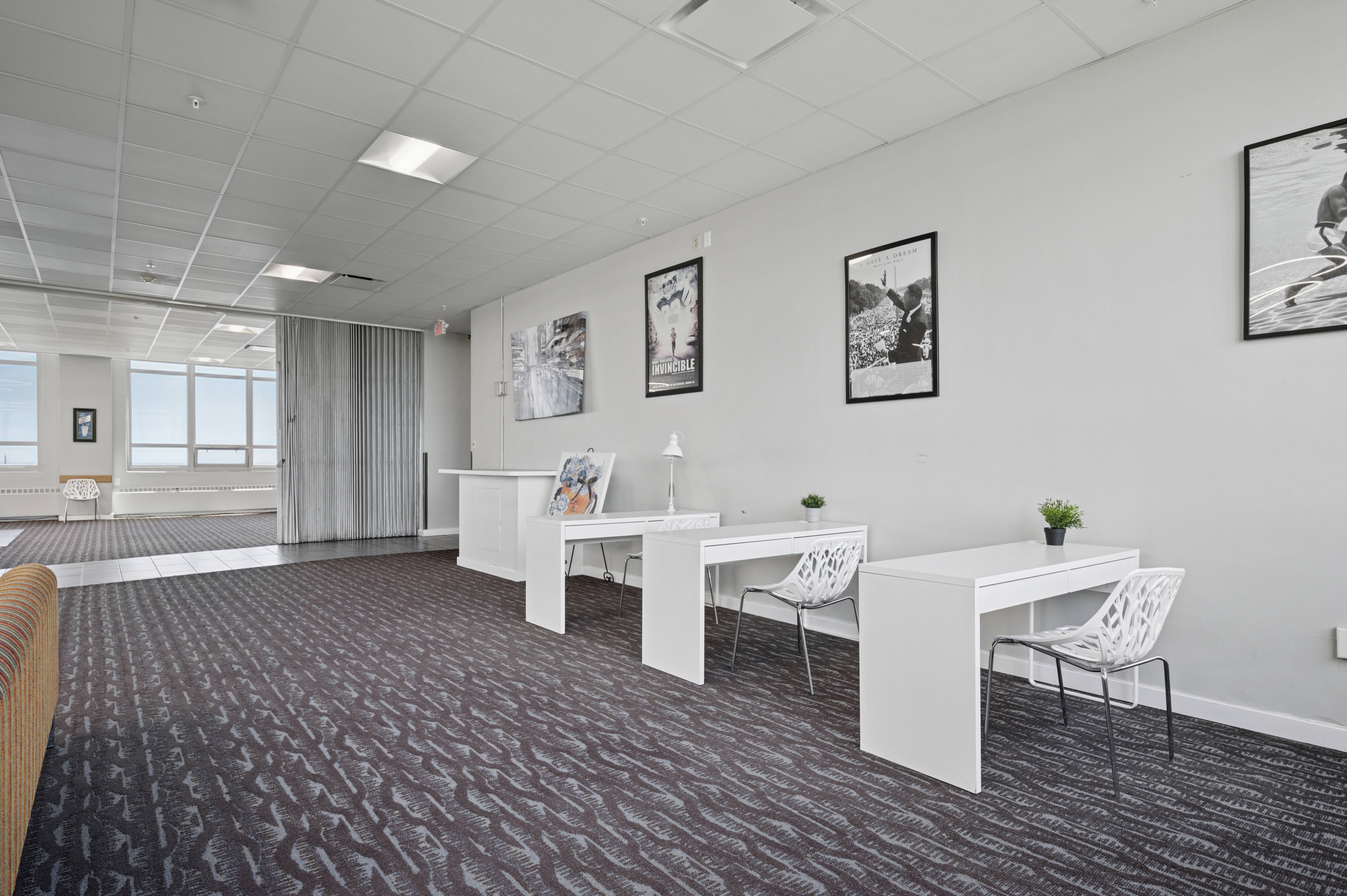 A room with a carpeted floor and white furniture.