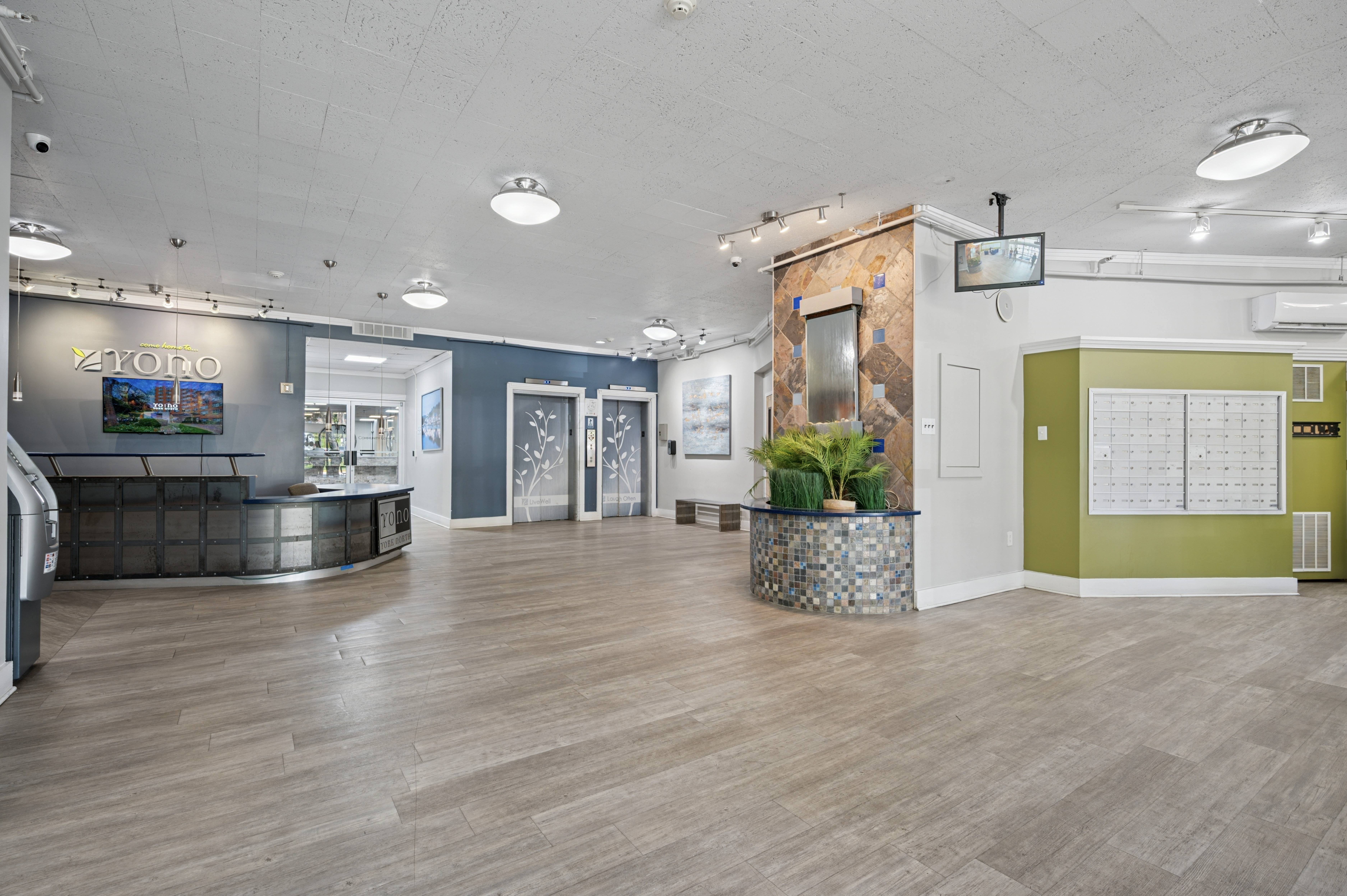 A spacious office lobby with a reception desk and a calendar on the wall.