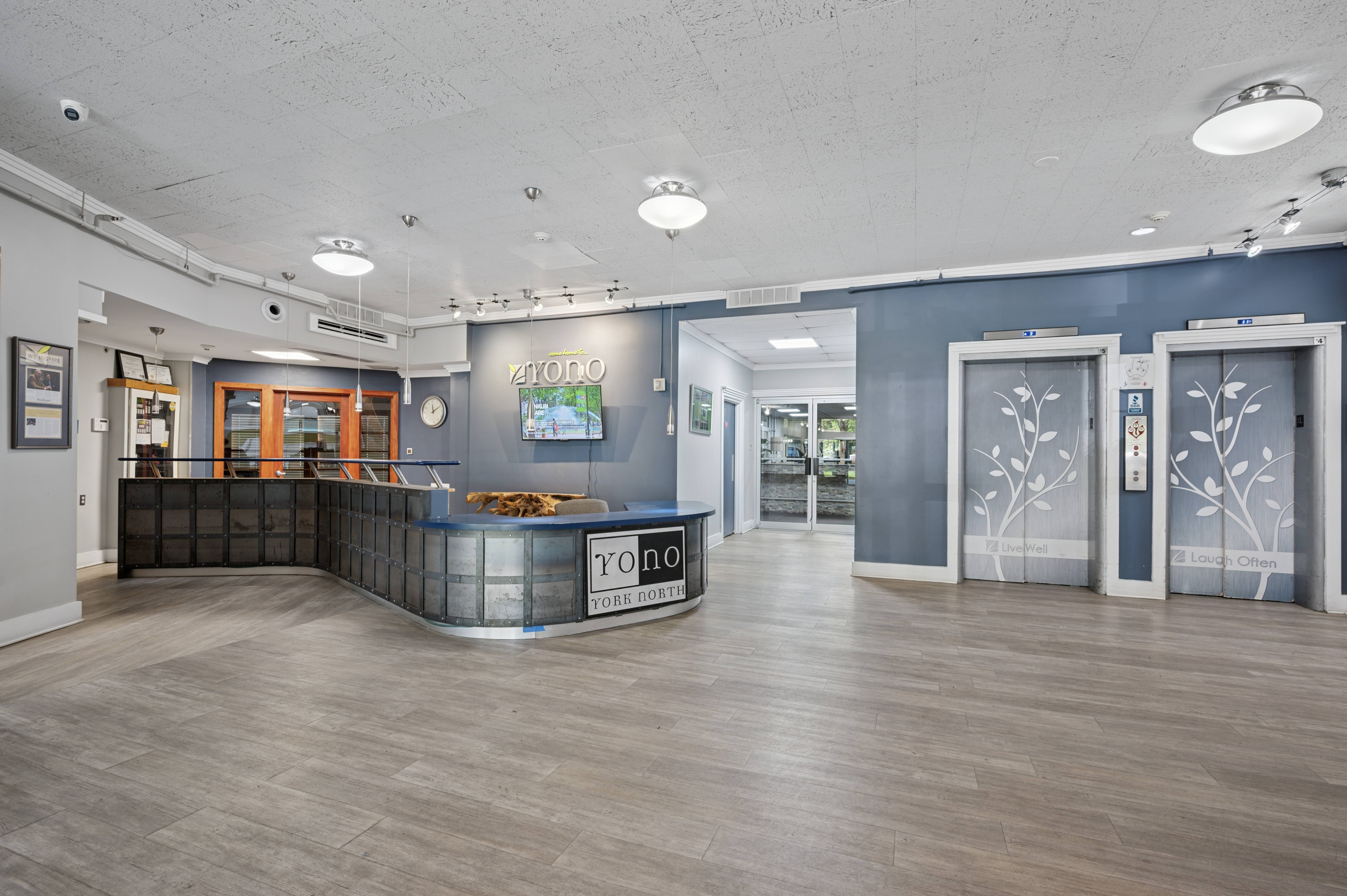 A reception area with a blue wall and a wooden floor.
