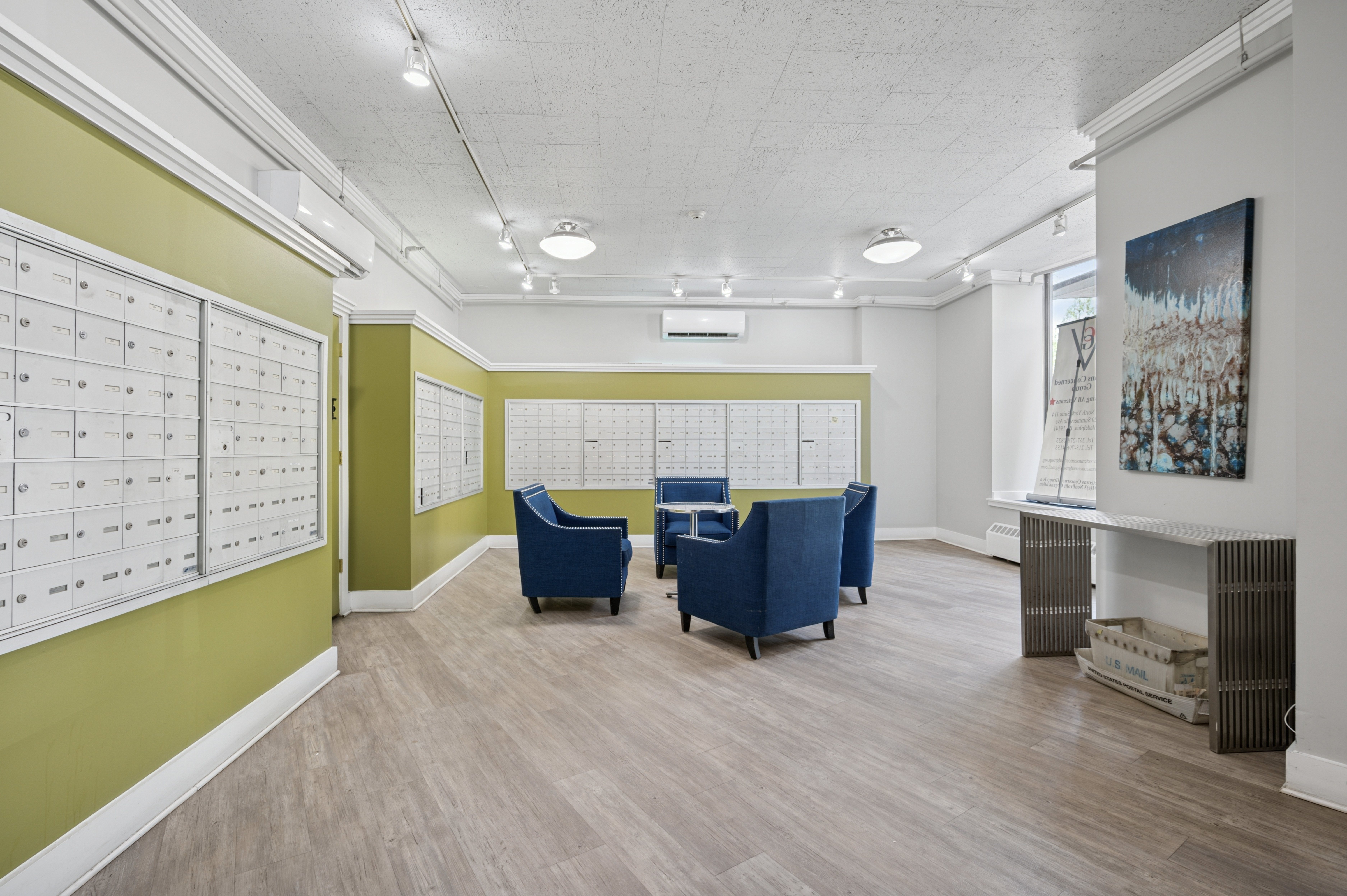 A room with a green wall and a white wall with a calendar on it.