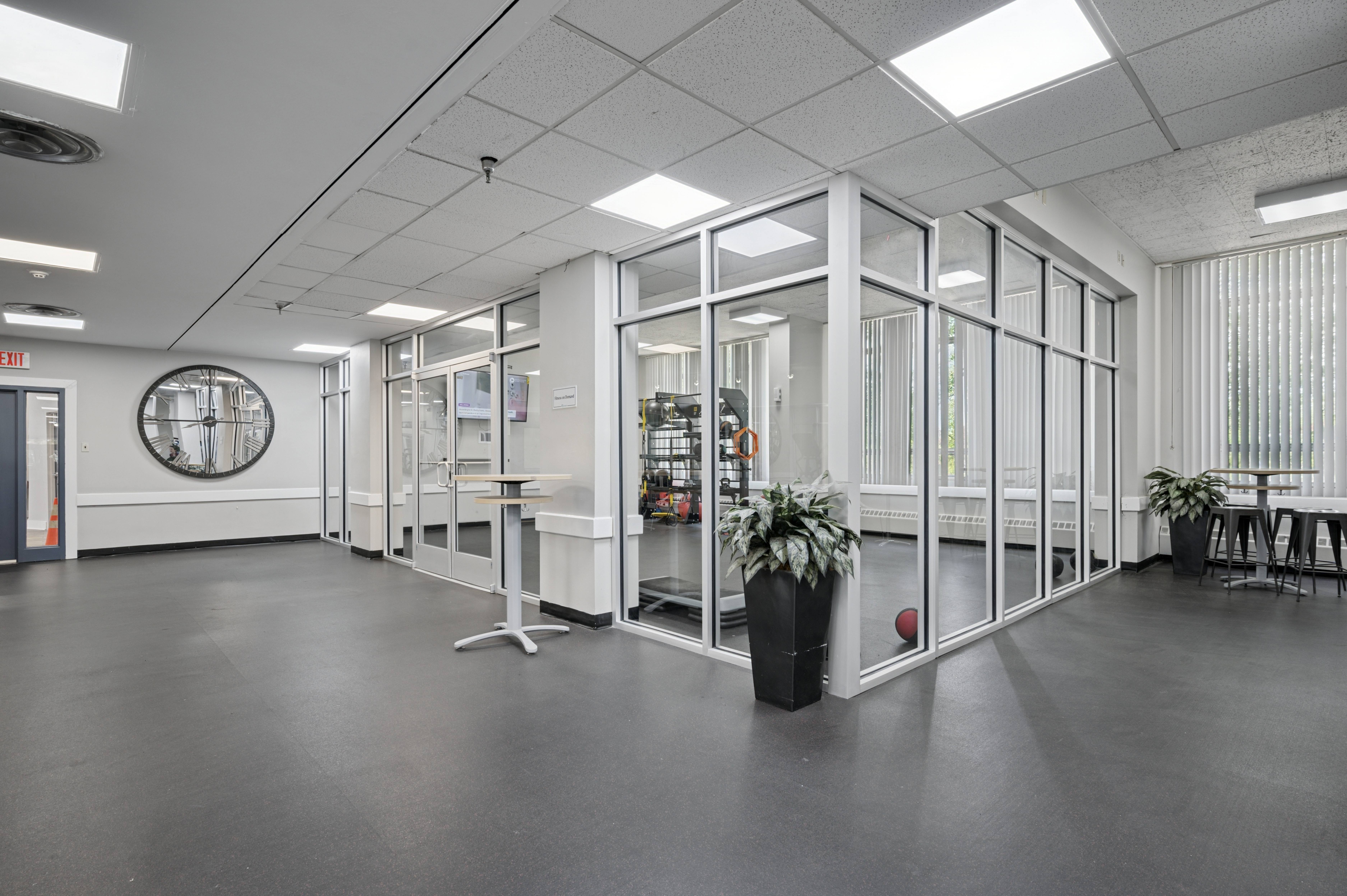 A large open office space with glass walls and a basketball on the floor.