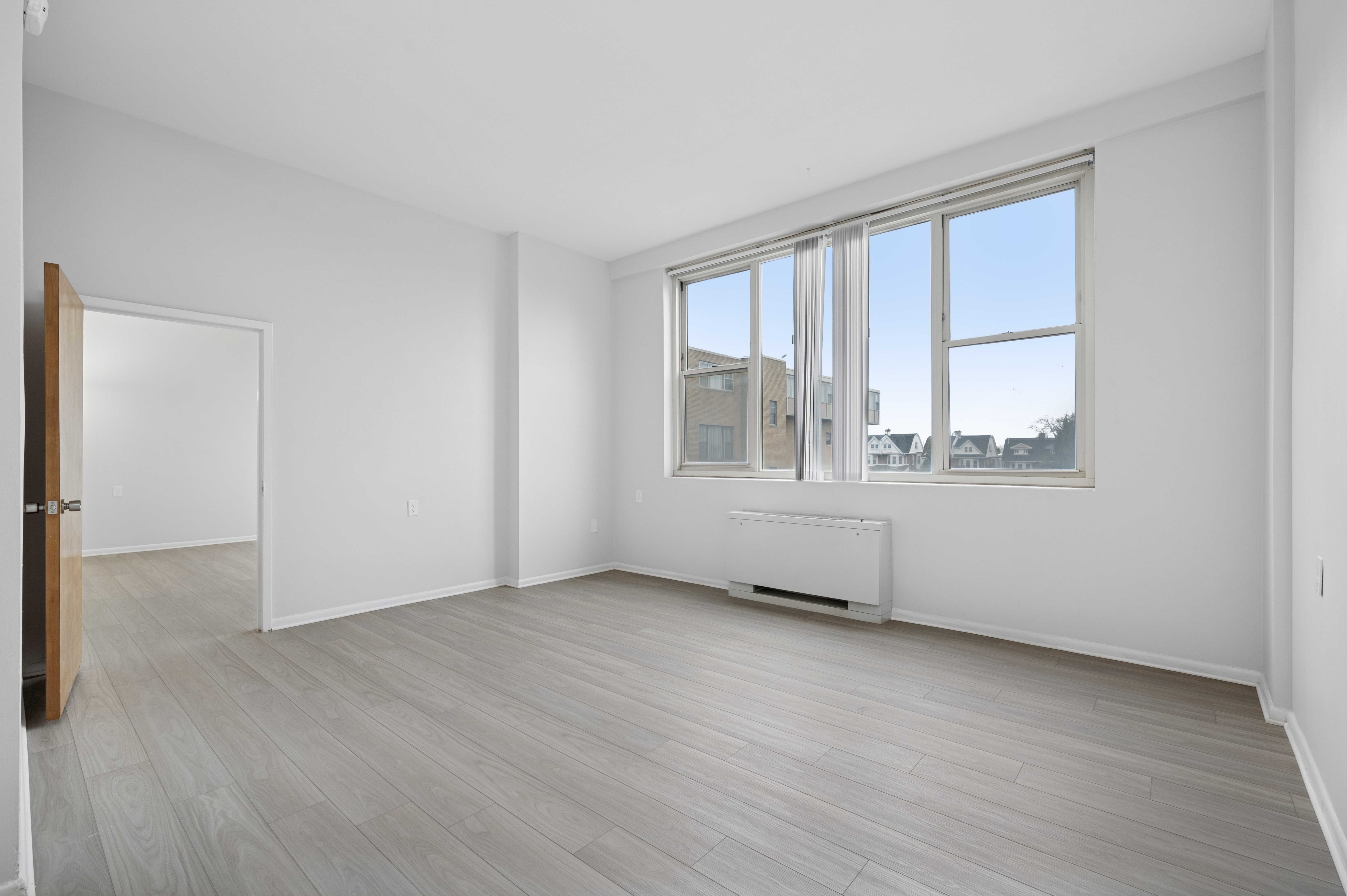 A room with a large window and a radiator on the floor.