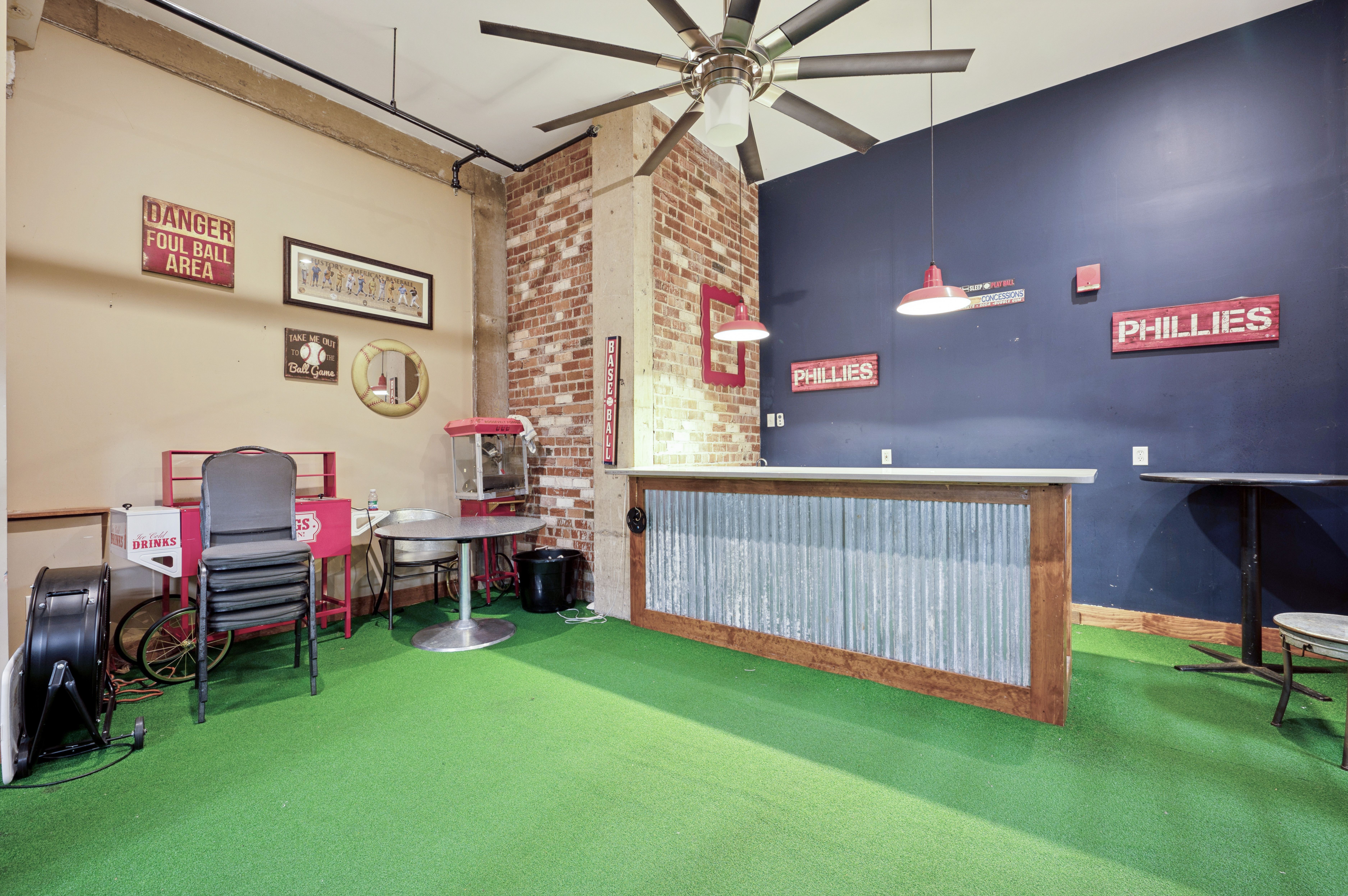 A room with a green carpet and a ceiling fan.