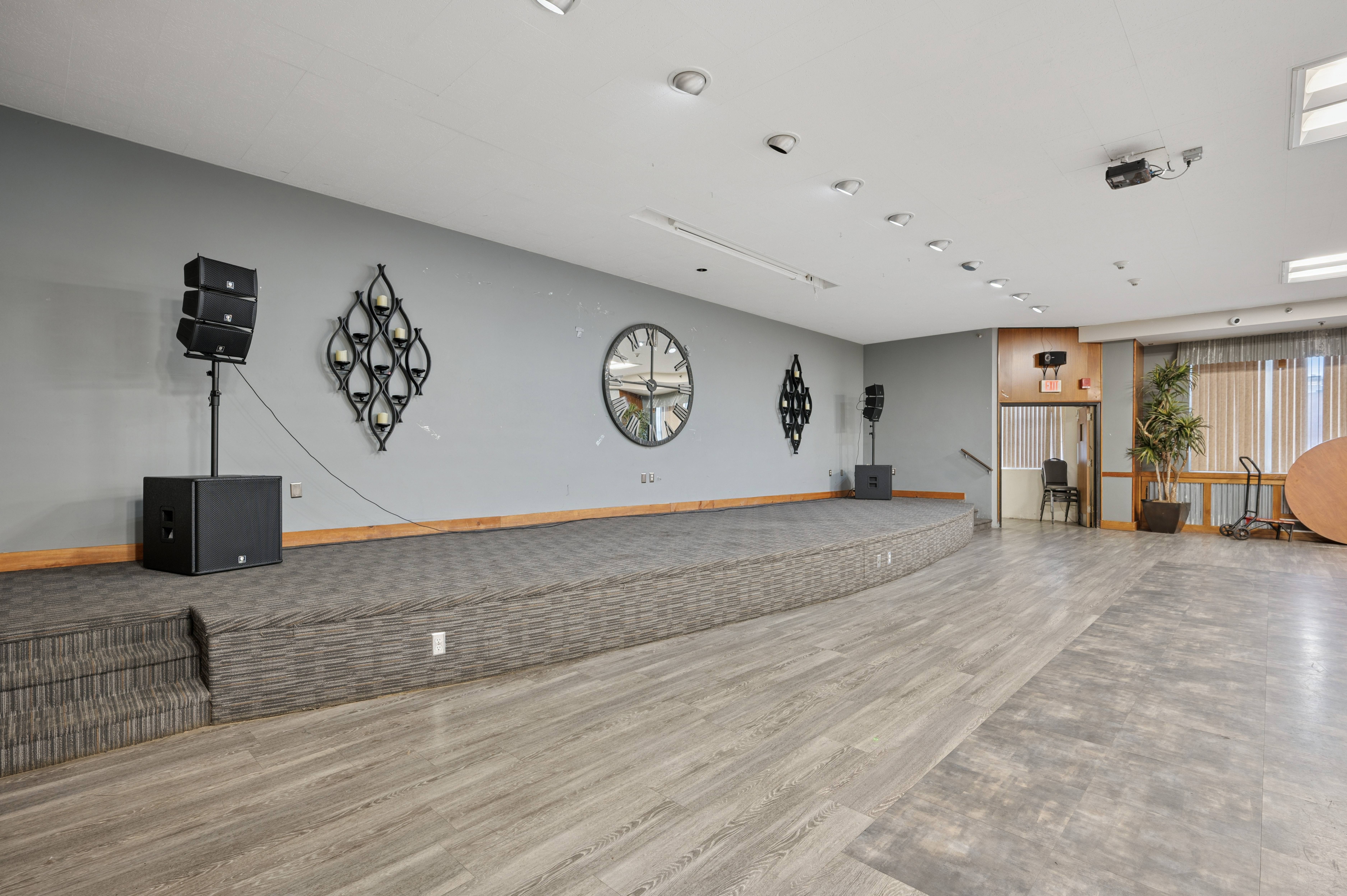 A room with a stage and speakers.