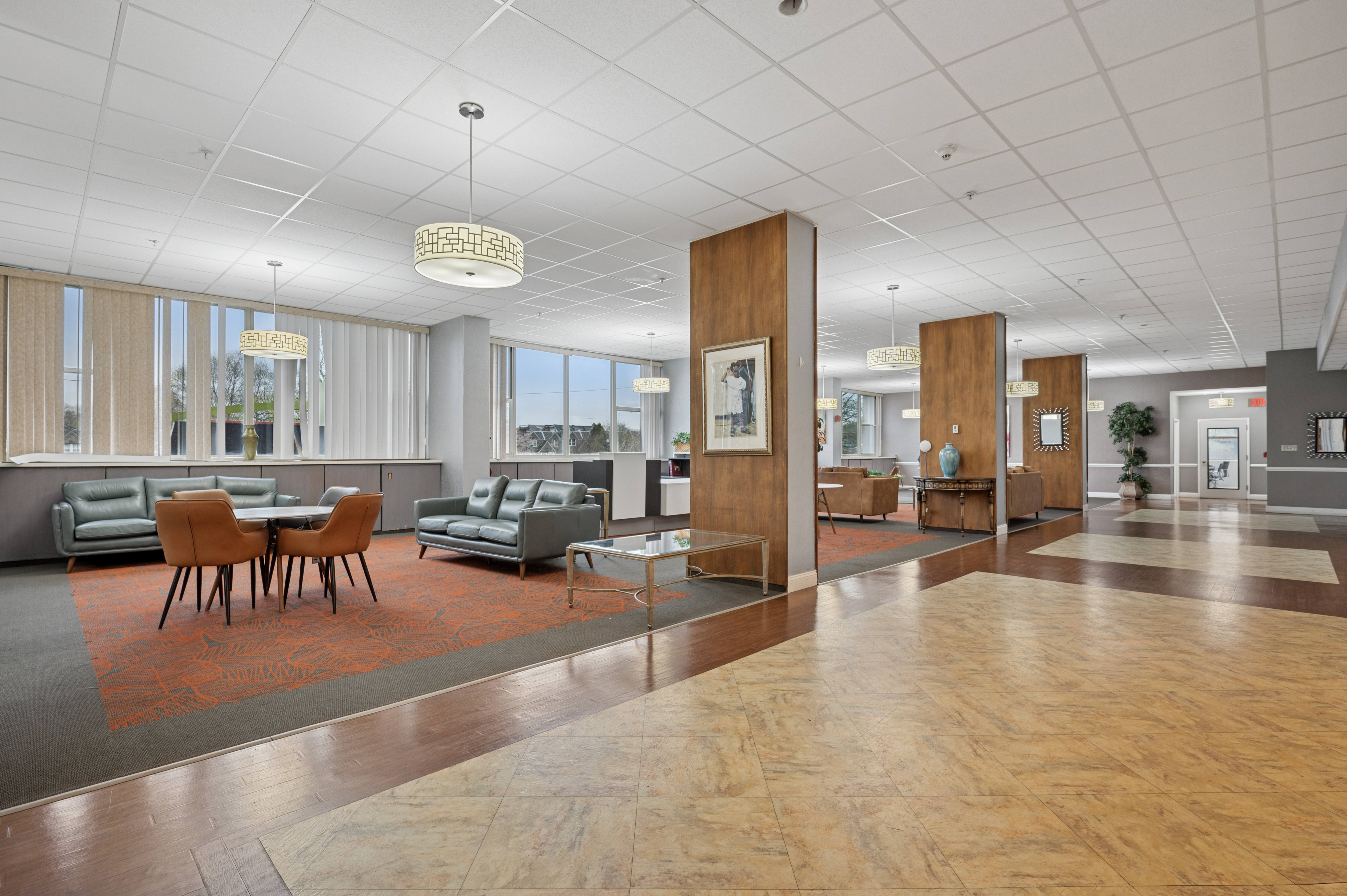 A spacious room with a long wooden table and chairs.
