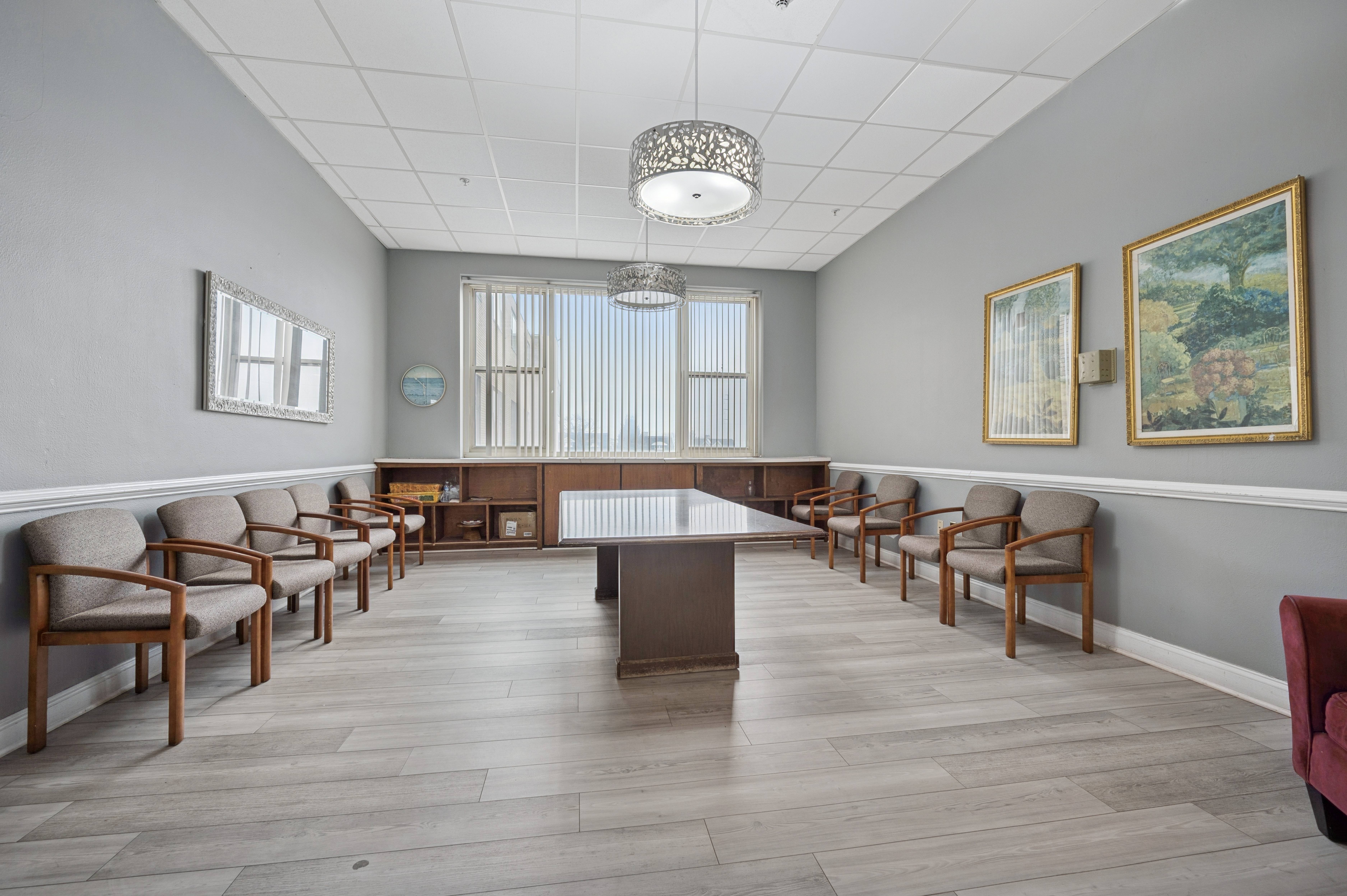 A conference room with a long table and chairs.