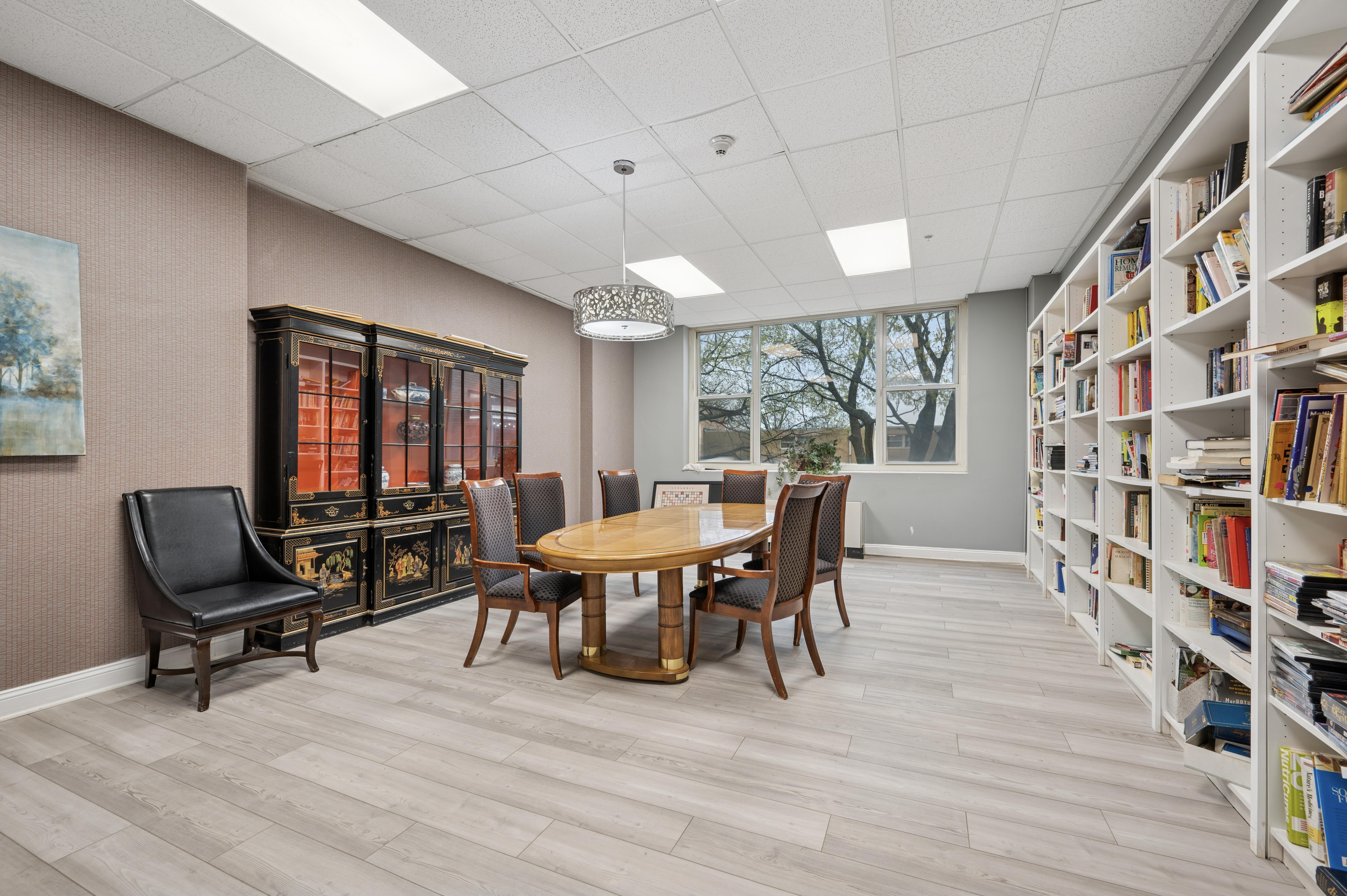 A room with a table, chairs, and a bookshelf.