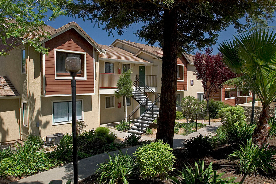 The exterior green landscaping of the Belmont Apartments in Pittsburg, California.
