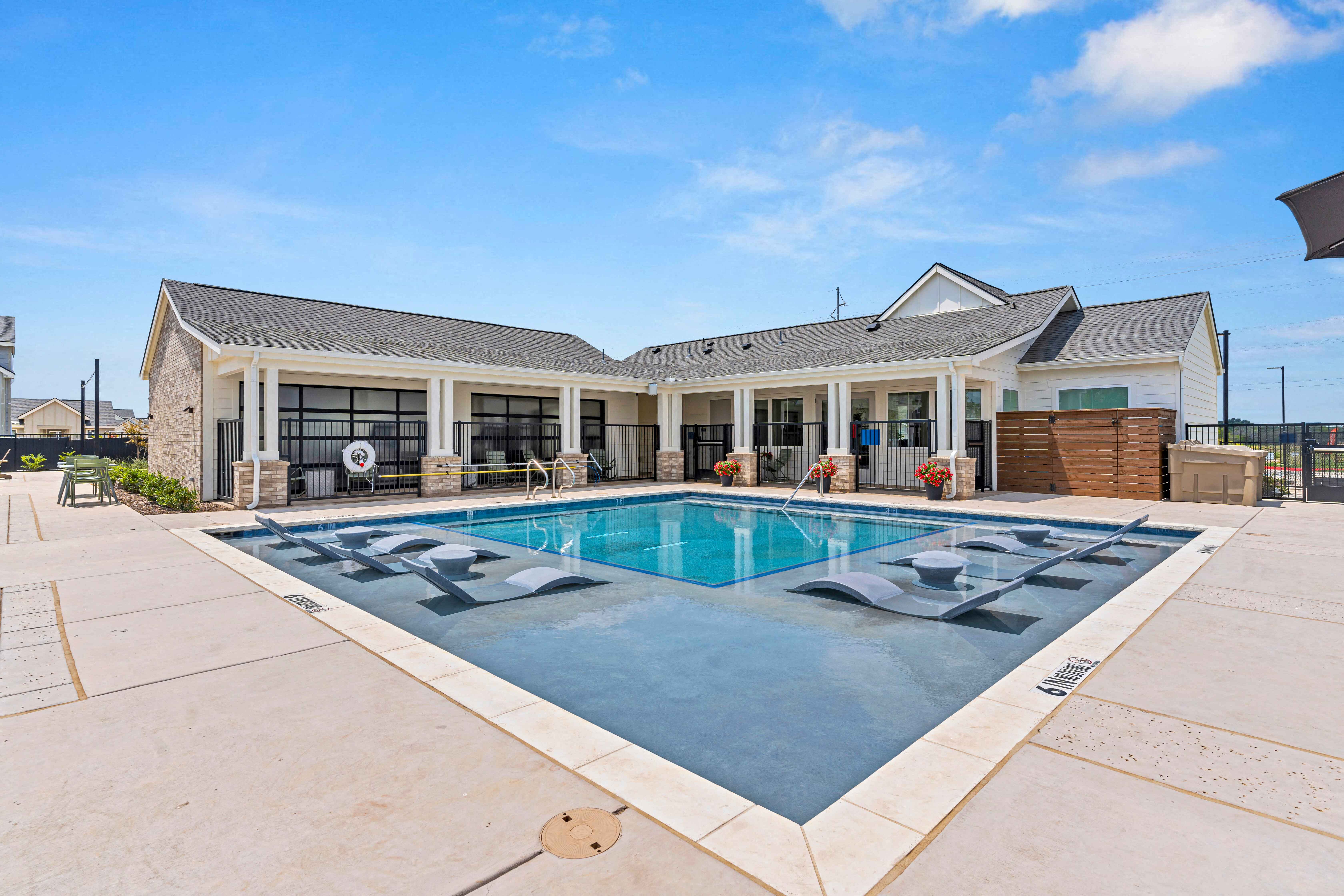 a swimming pool with a house in the background