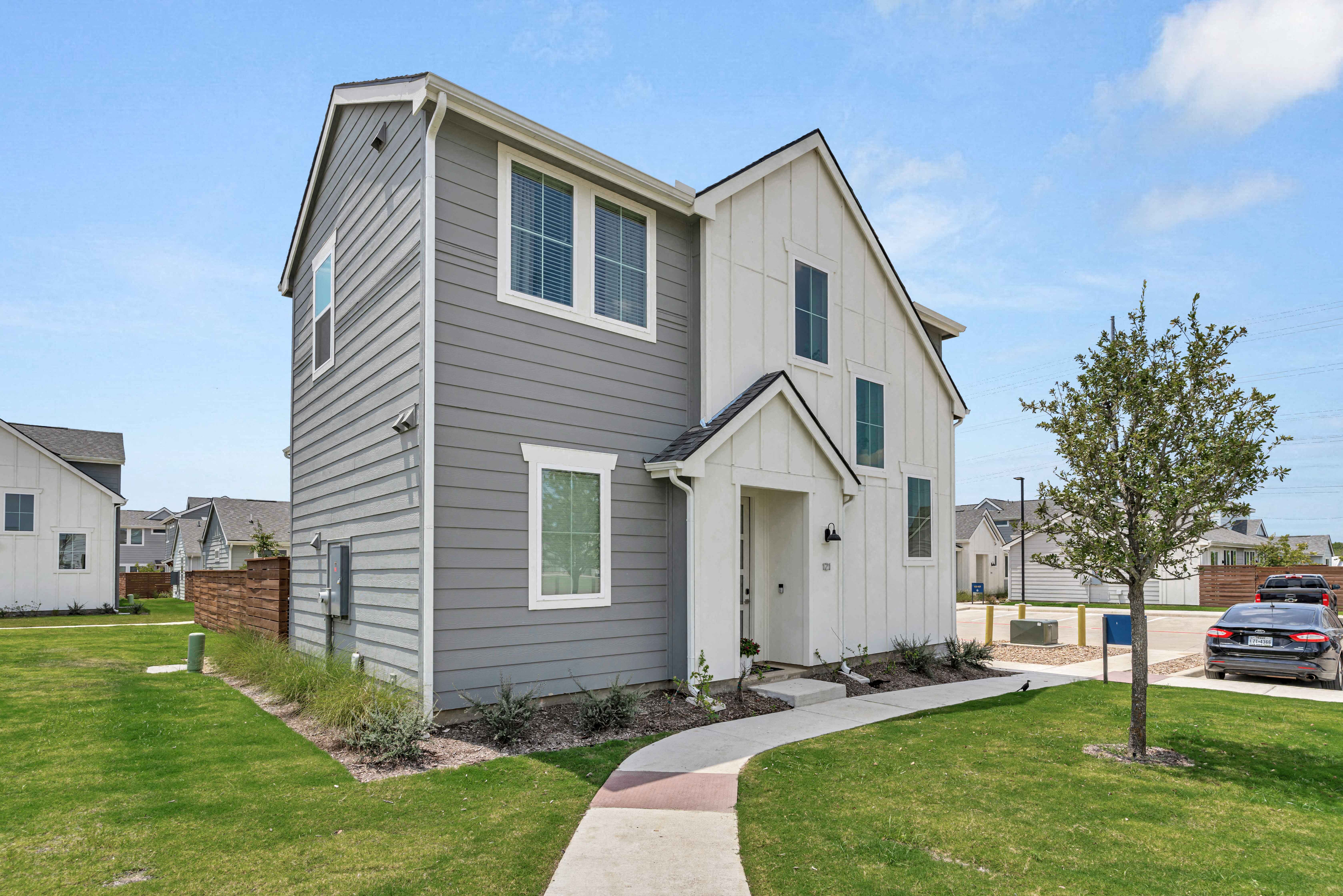 the front of a house with a sidewalk and grass