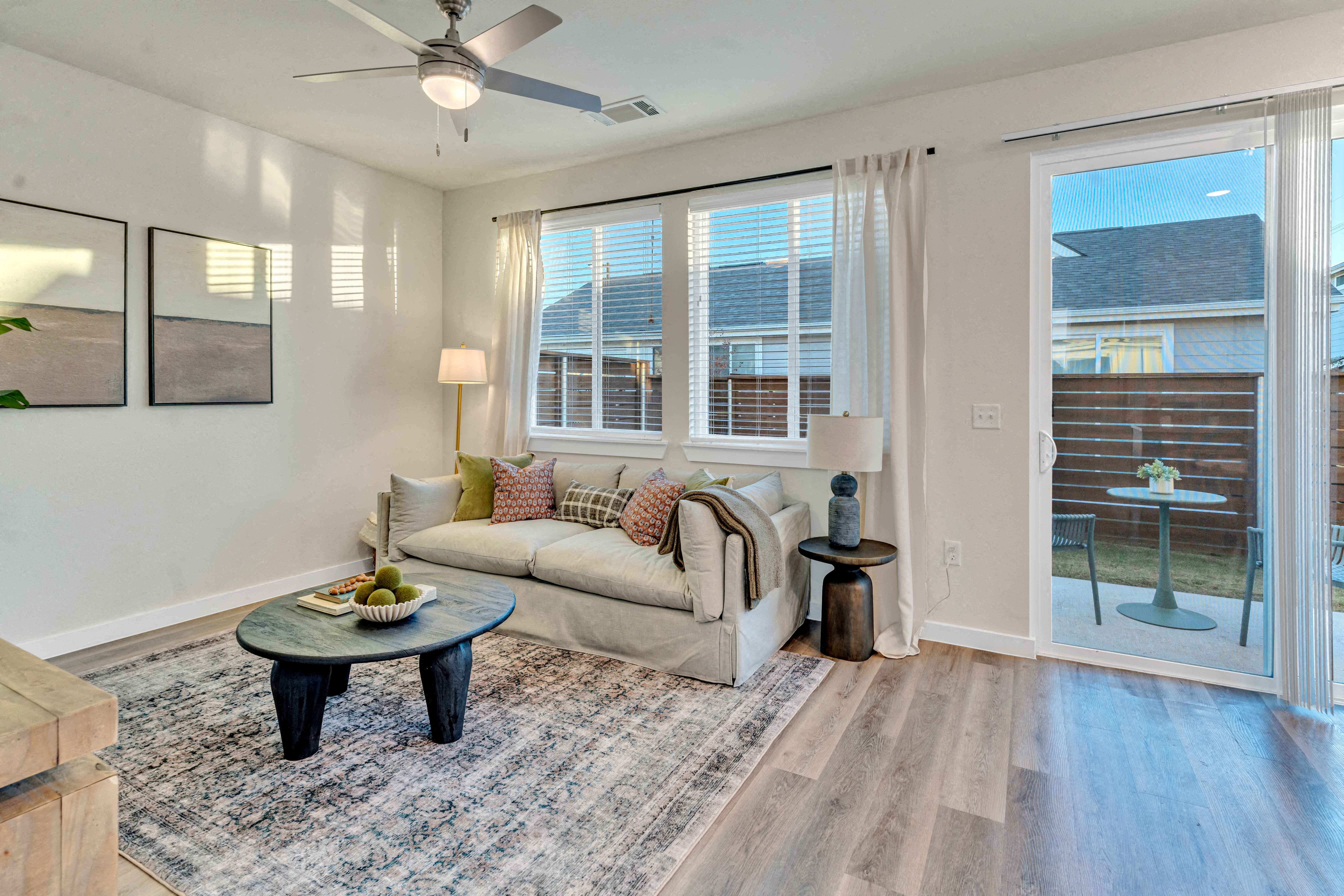 A living room with a couch, a coffee table, and a ceiling fan.