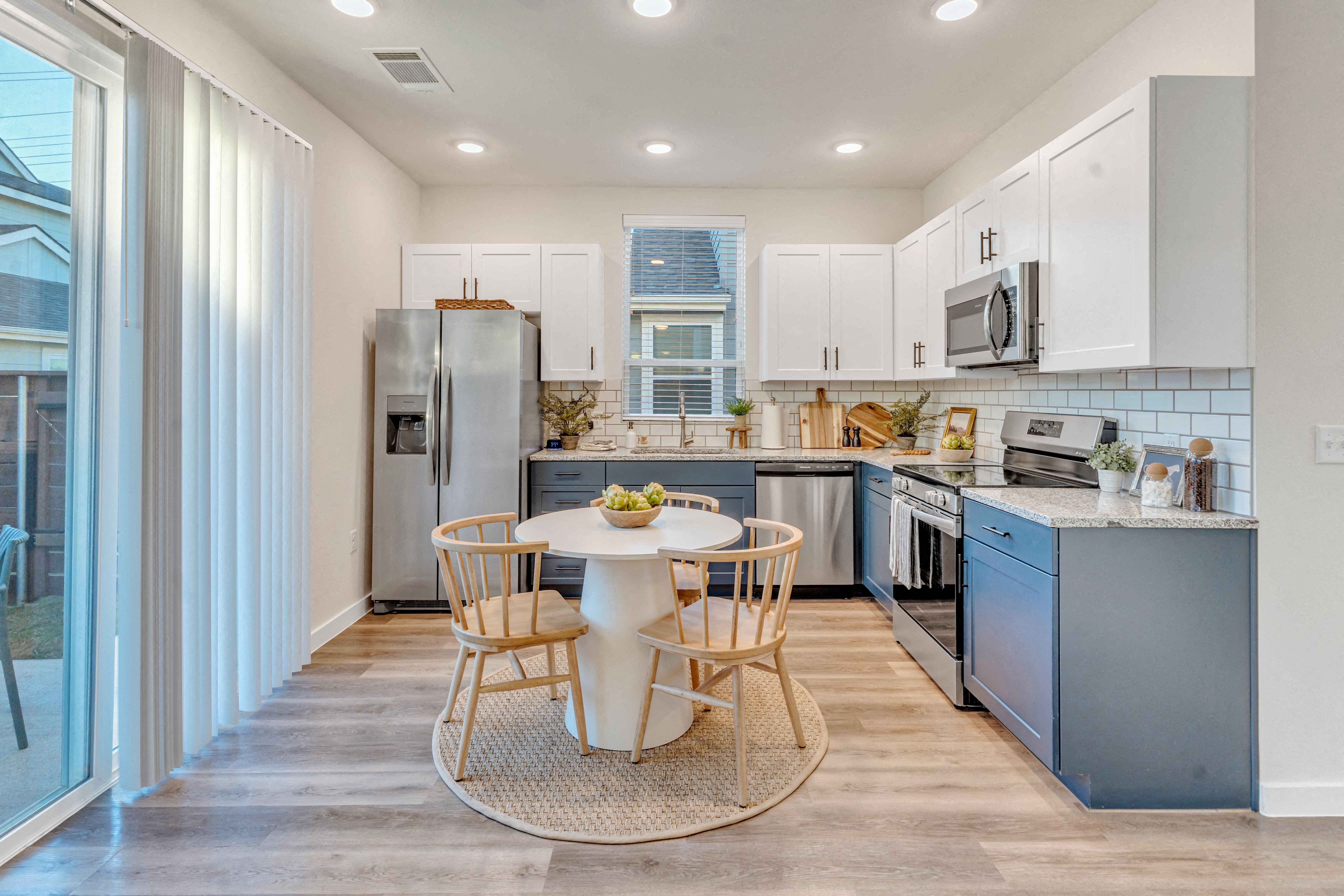 A kitchen with a table and chairs in the middle of the room.