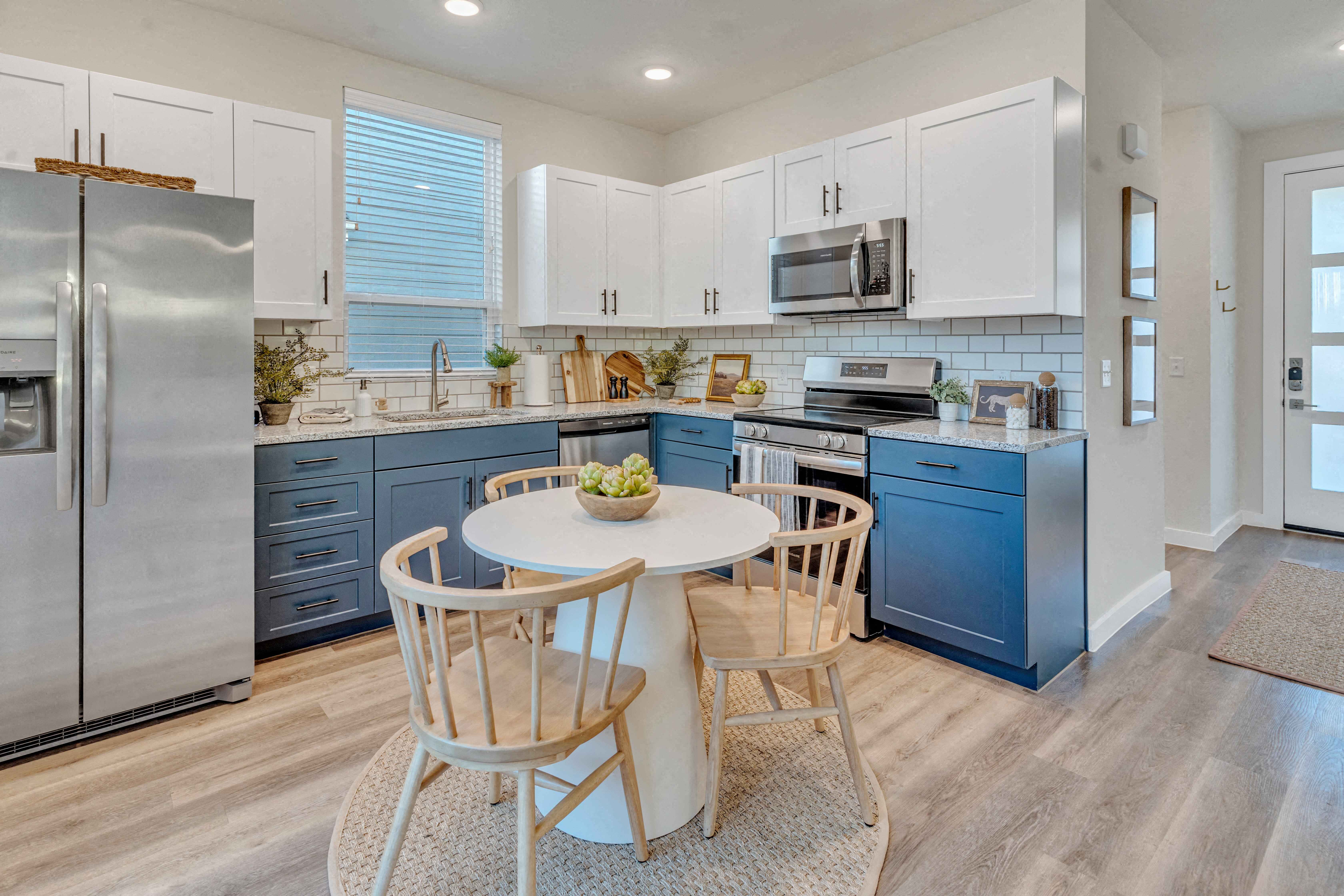 A kitchen with a table and chairs in the middle of it.