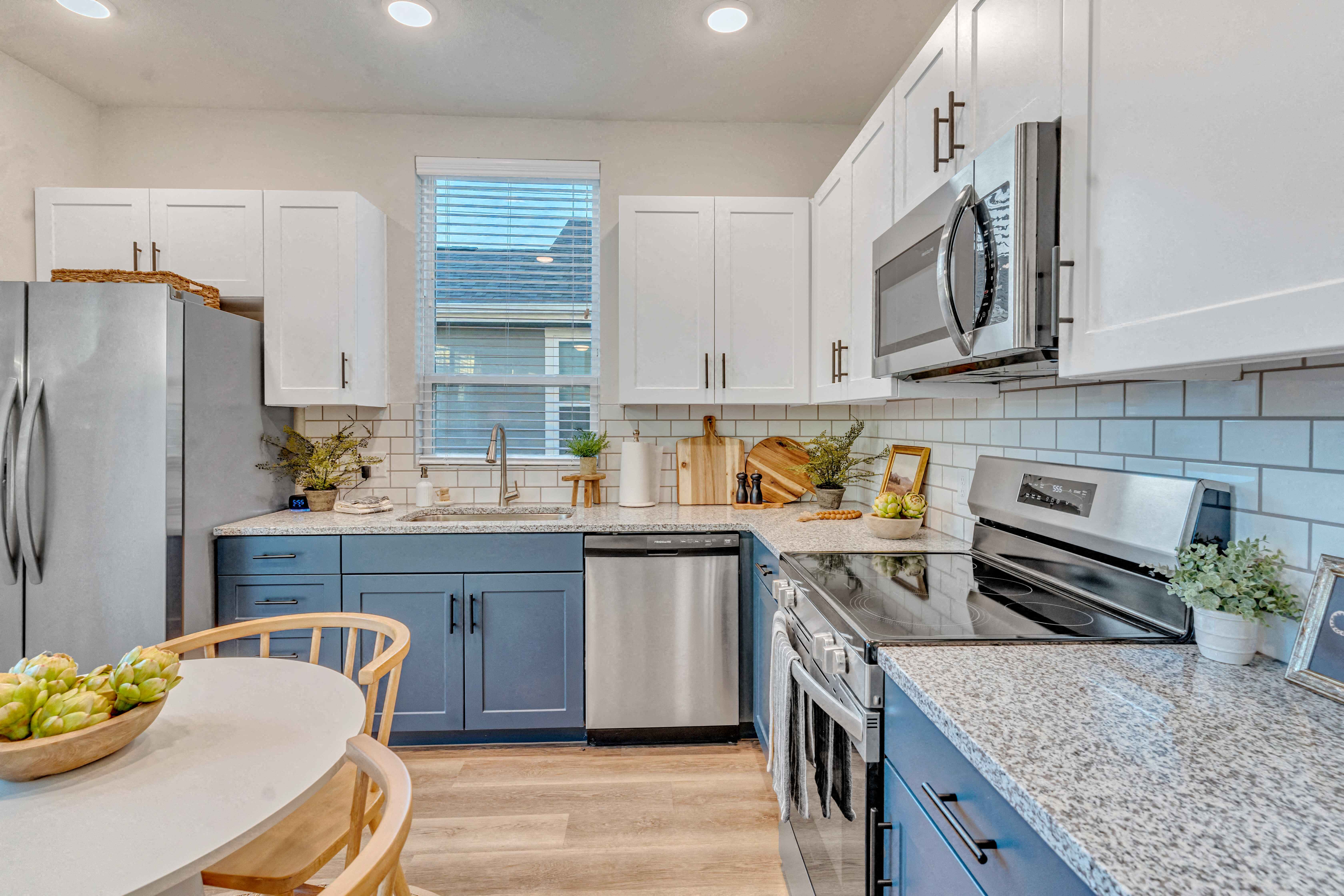 A kitchen with a refrigerator, microwave, and oven.