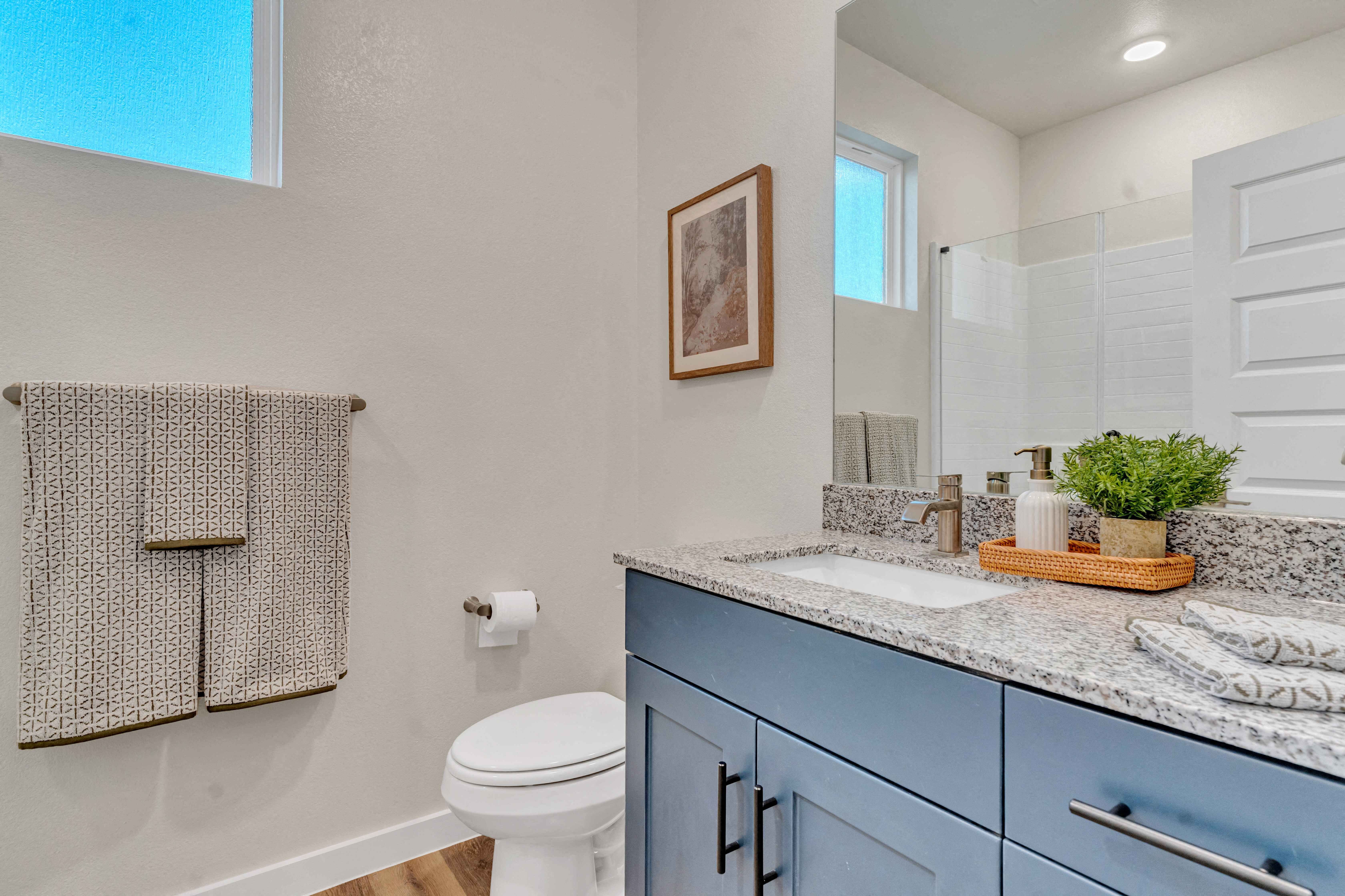 A bathroom with a toilet, sink, and a window.