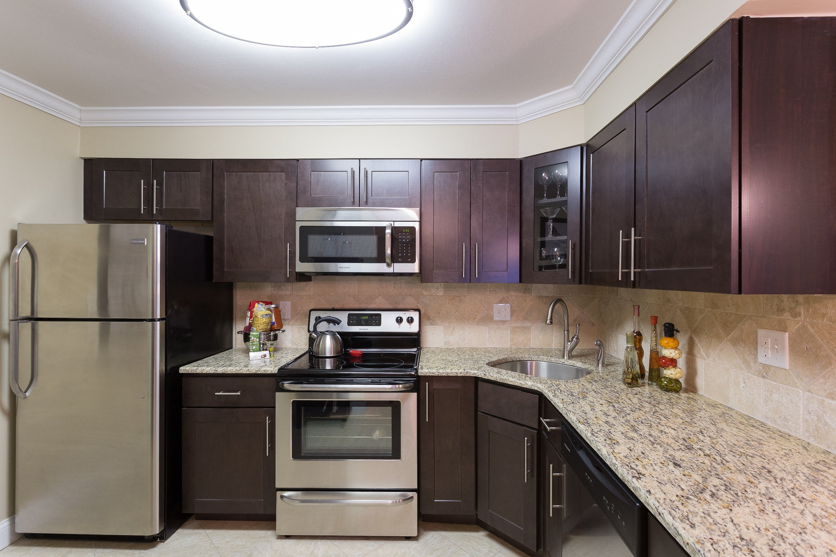Kitchen with silver appliances, granite counter tops, and tile backslash