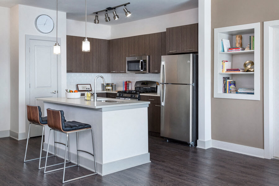 A spacious kitchen with hardwood floors and a kitchen island at the Talia Apartments in Marlborough, Massachusetts.