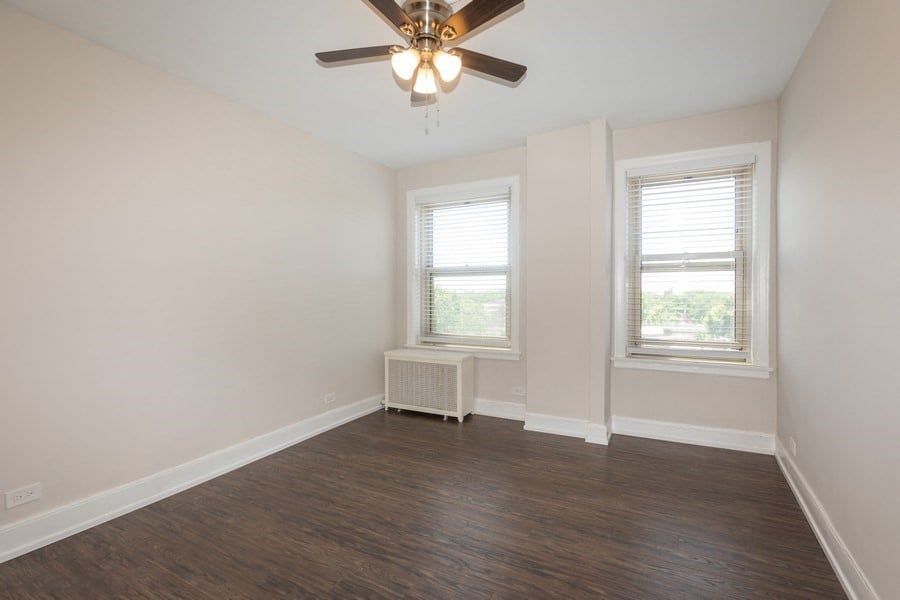 bedroom with hardwood flooring, windows, and ceiling fan in hyde park chicago
